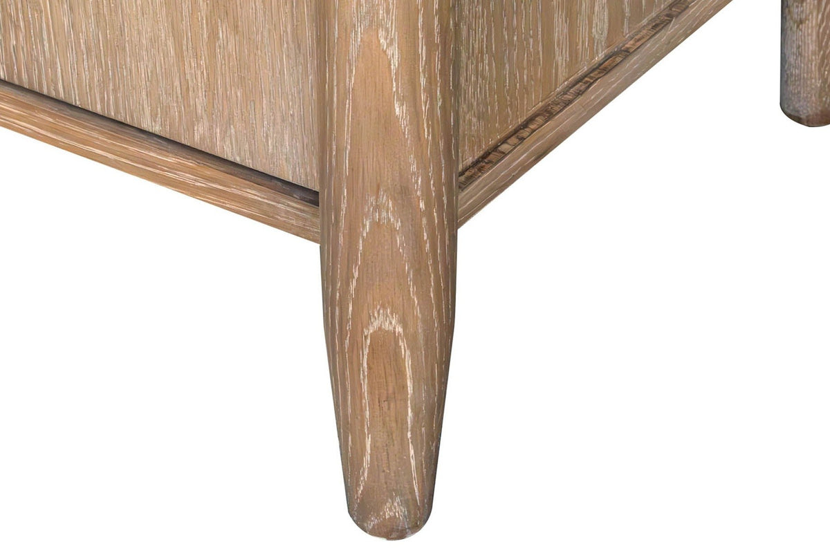 Close-up of a round tapered oak leg of the Sarnano sideboard in Sand, with the slim bottom rail above it