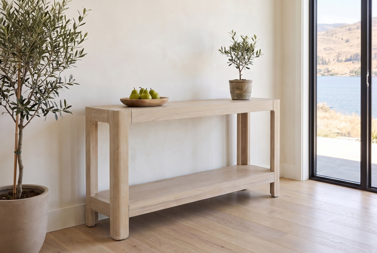 Sarnico console table in natural in the bright entry of a lake house, pears in a wooden bowl and a small olive tree on top