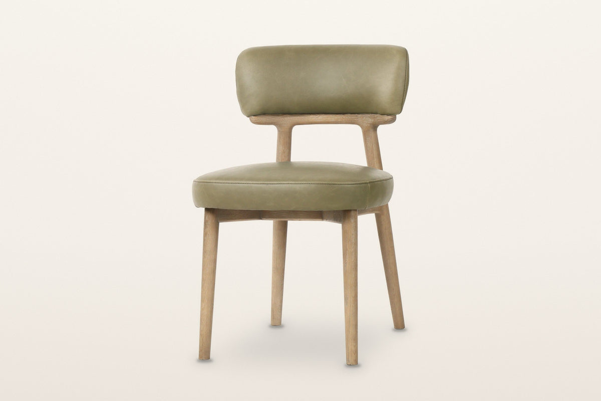 Savoca dining chair in Sage Green leather, three-quarter view on a warm white studio backdrop