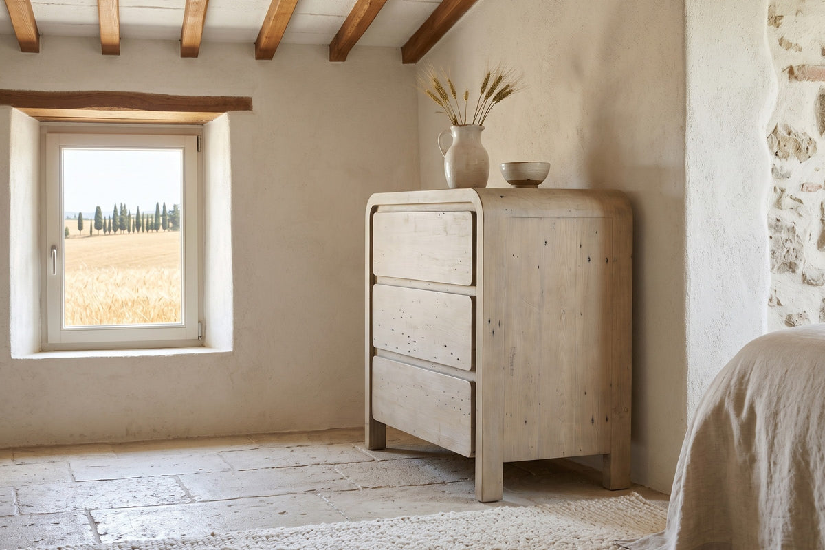 Scheggino chest seen from the side in a Volterra farmhouse bedroom, with rough plaster and stone walls, chestnut beams