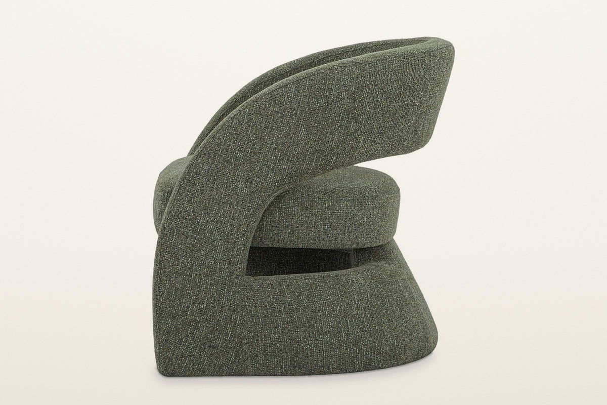Sefro accent chair in Green from the side on a warm white studio backdrop: the panel sweeping up into the back band and a slo