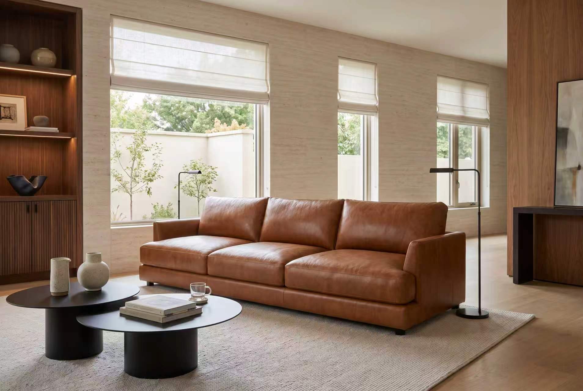 Serena three-seat leather sofa in Cognac in a bright room with tall windows