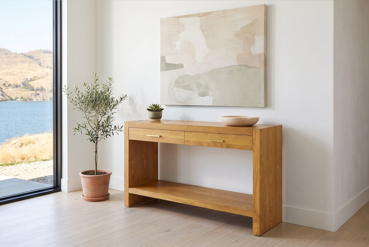 Sibari console table in Natural in the white entry of a Kelowna lake house beside a small olive tree