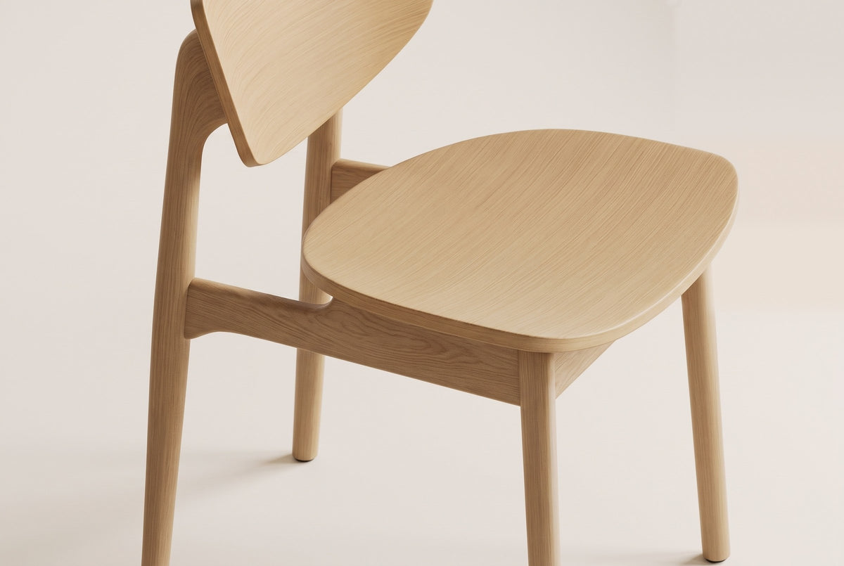 Natural honey oak Simone chair, close-up of the contoured seat, back panel, post and side-rail joint on a plain warm off-white studio backdrop