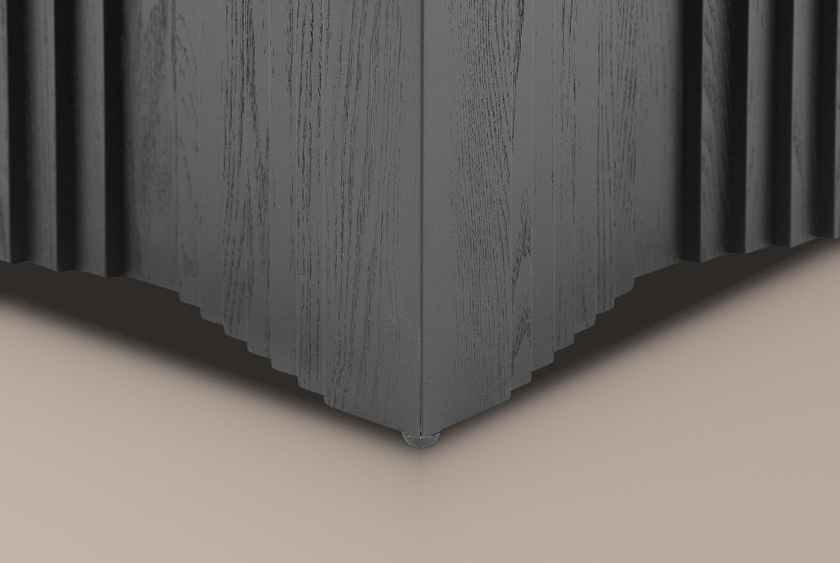 Close-up of a bottom corner in Black: the edge rising in small steps and a black rubber pad