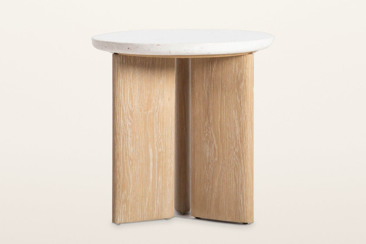 Sorano side table on a warm white studio backdrop, turned to show the three oak slabs meeting under the top like a pinwheel