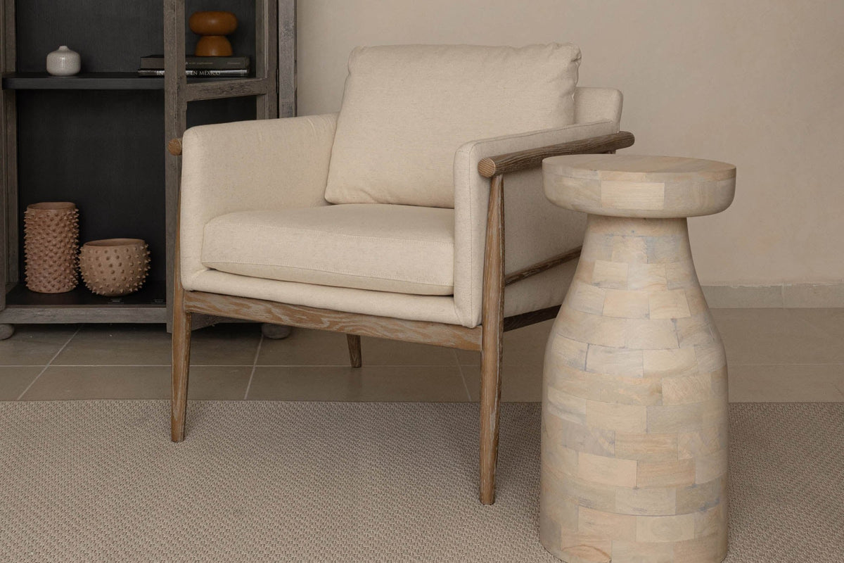 Soren beige fabric accent chair beside a stone side table in a neutral living room