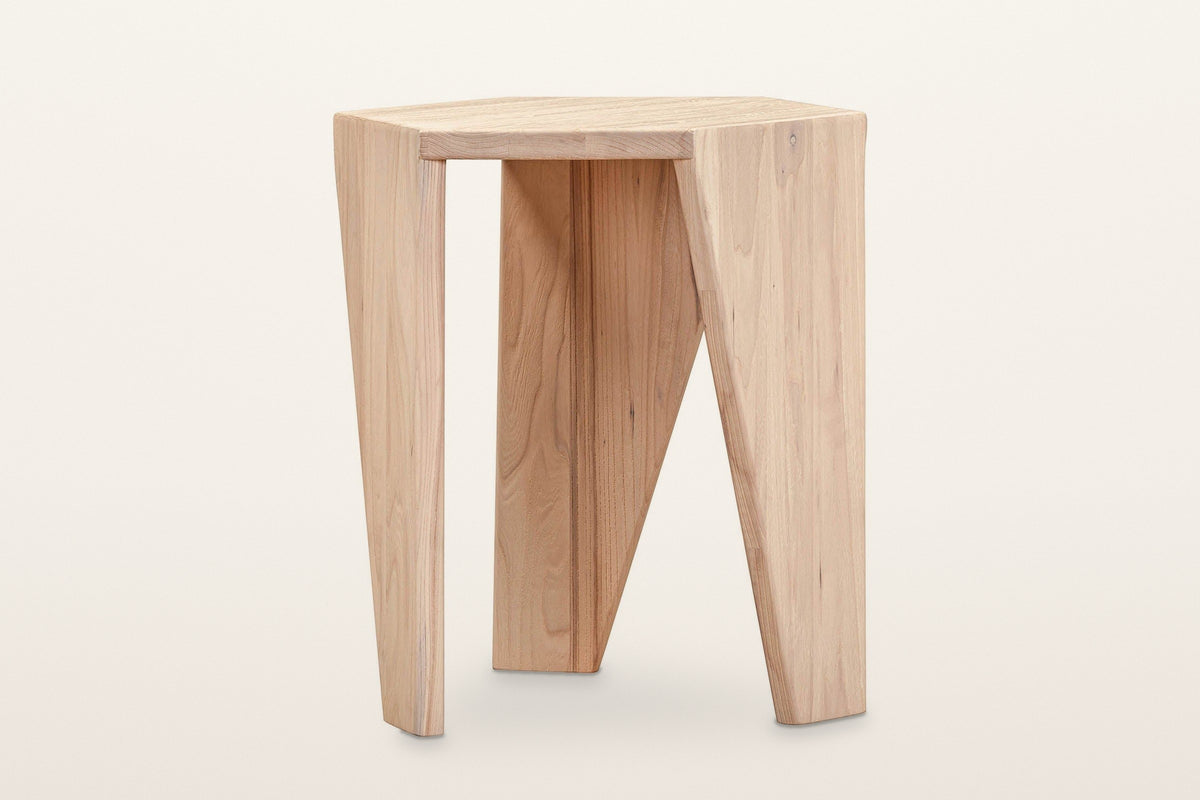 Sovana side table in Sandblast White Elm from the front, on a warm white studio backdrop: three legs under the hexagon top