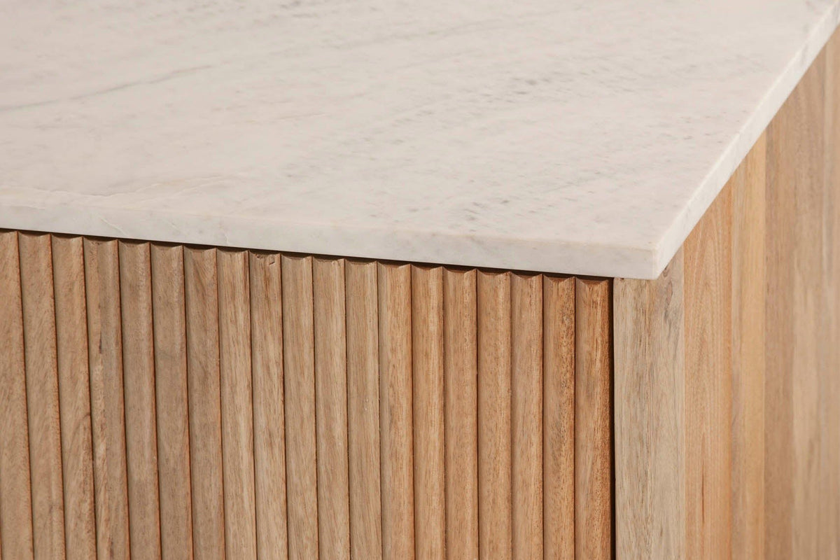 Close-up of the Staffolo sideboard corner in Natural: the white marble top with soft grey veins over the rounded mango reeds