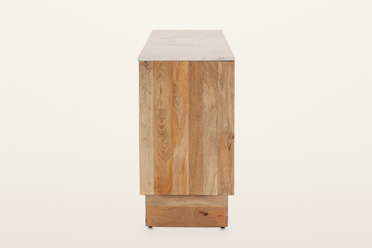 Staffolo sideboard in Natural, end view on a warm white studio backdrop: an end panel of wide mango boards under the marble t