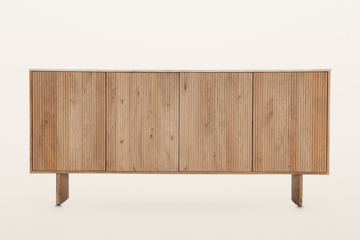 Staffolo sideboard in Natural, straight front view on a warm white studio backdrop: four equal reeded doors under a thin whit