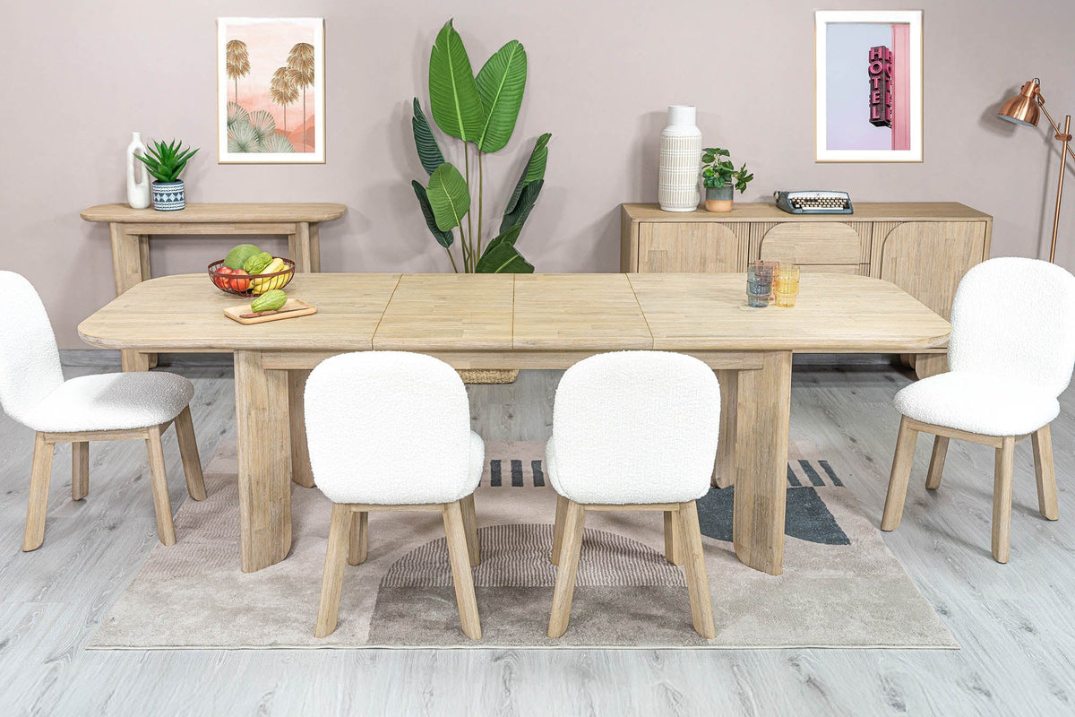 Sylvan dining table extended with six white chairs in a bright dining room