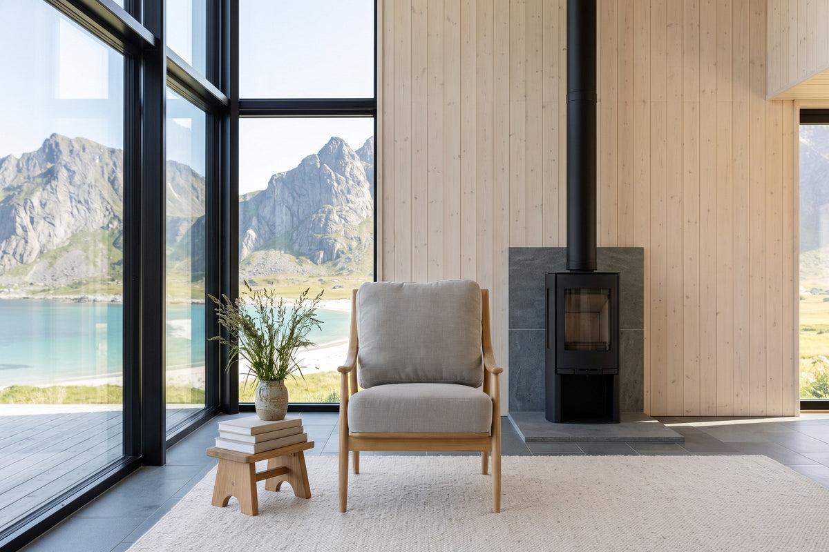 Tagliacozzo accent chair from the front in a Lofoten sea house, by a black wood stove and birch panelling