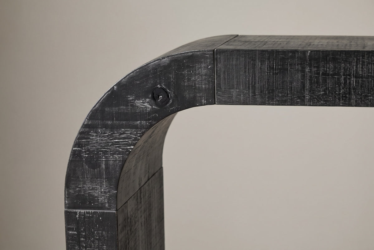 Close-up of the curved corner from the front: the bend and its fine seams to the top and to the leg