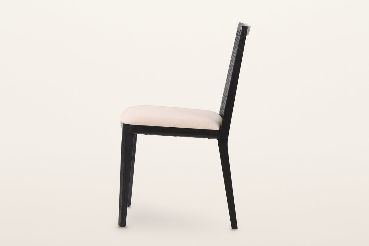 Teggiano dining chair in Black, side view on a warm white studio backdrop: the back reclines and its frame runs down into