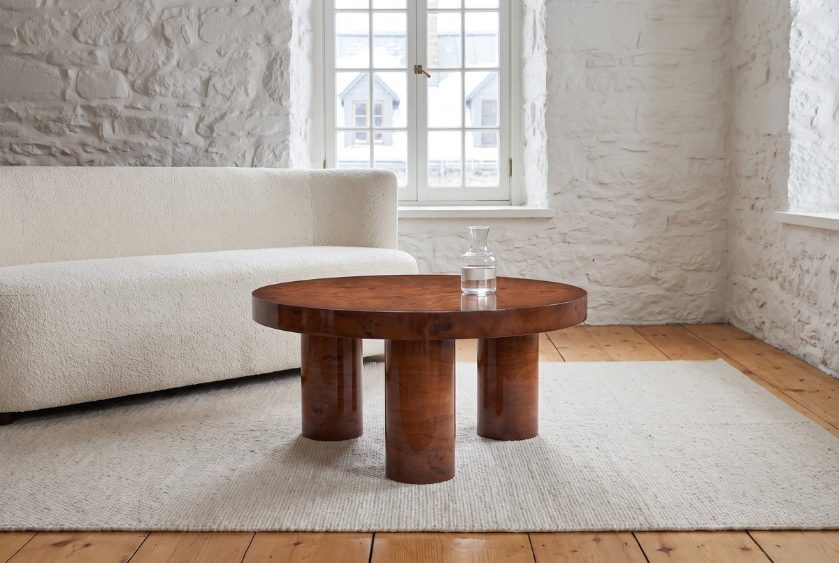 Teramo coffee table in front of an ivory boucle sofa in a whitewashed stone room in Quebec City, a glass carafe on top