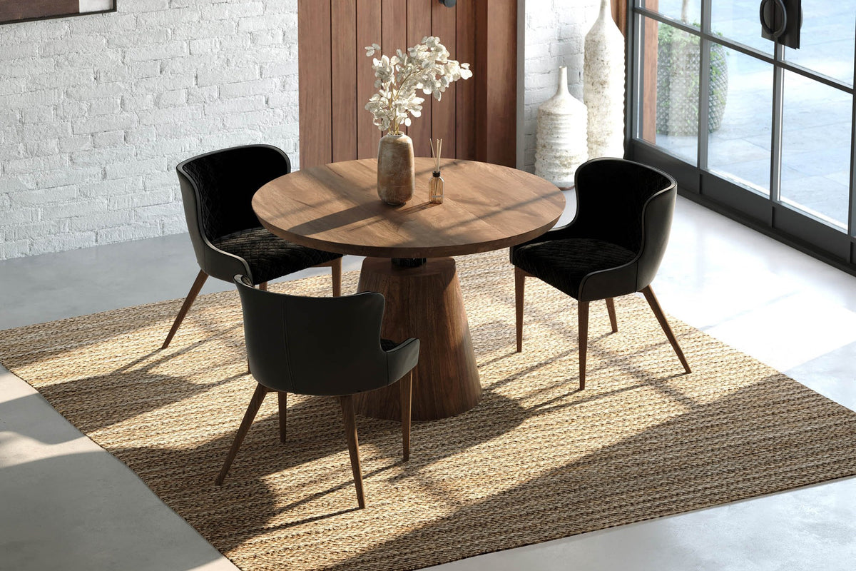 Thorne round acacia dining table seen from above with black chairs by a tall window