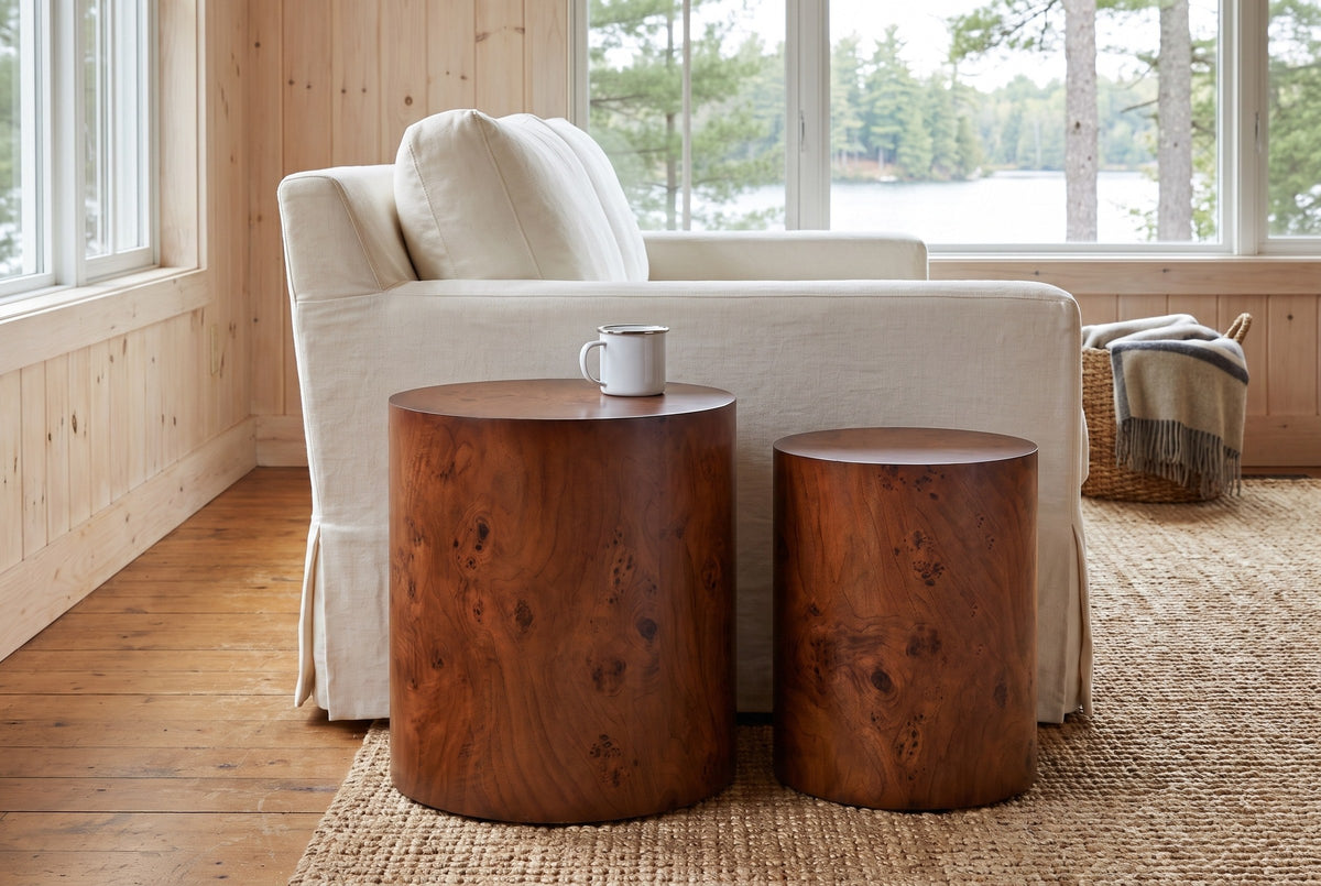 Tirano drum side tables beside a slipcovered sofa in a pine-panelled Muskoka cottage with a lake view