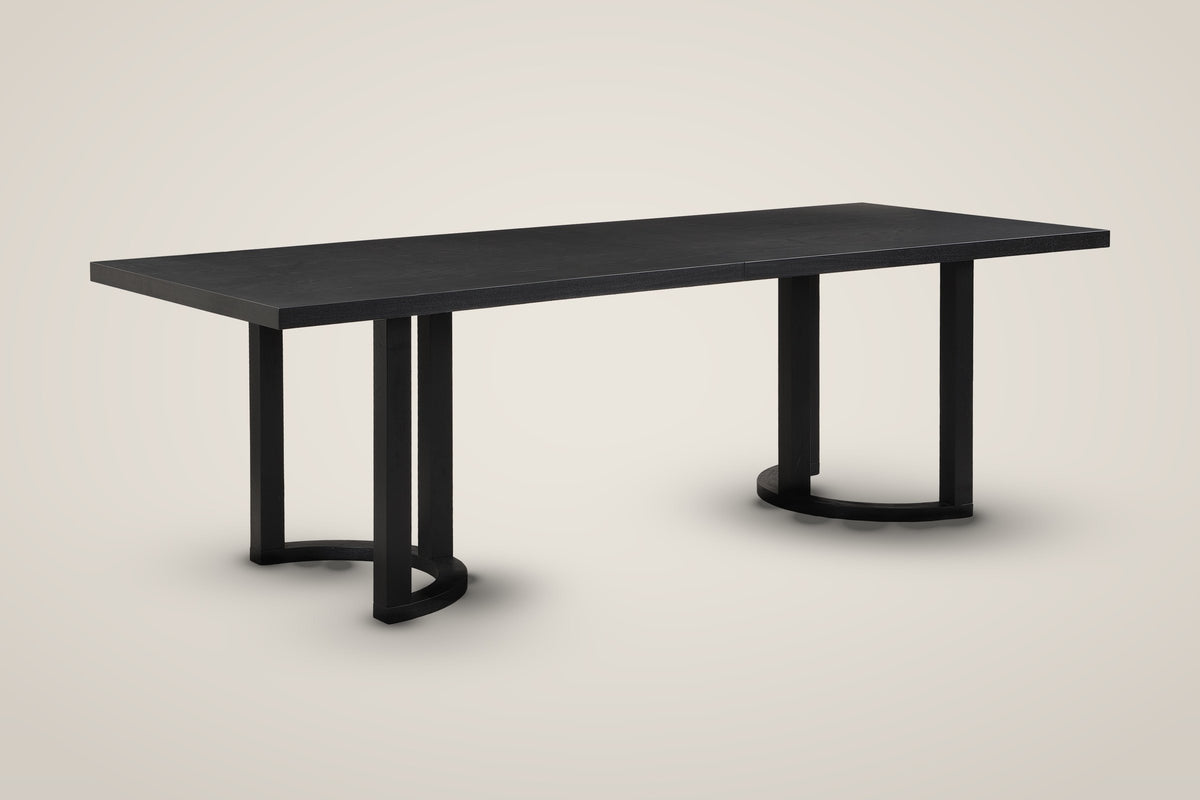 Tolmezzo 95-inch black dining table on two U-shaped trestle bases with half-moon feet, three-quarter view