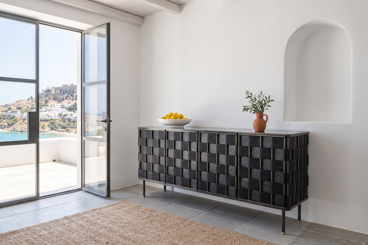 Trequanda sideboard in Black against lime plaster with an arched niche in a white house in Lindos, Rhodes