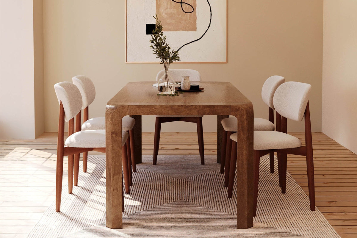 Tristan dining table set with six cream chairs under a woven pendant, end view