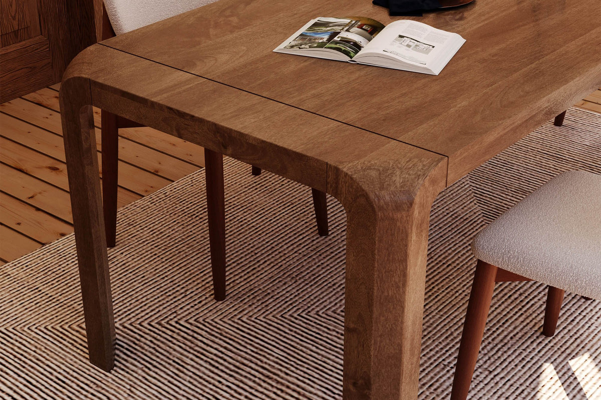 Tristan mango wood tabletop corner with natural grain and a rounded leg