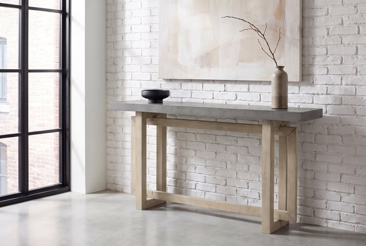 Urbania console table in Gray against a whitewashed brick wall in a loft entry, a branch in a stoneware vase