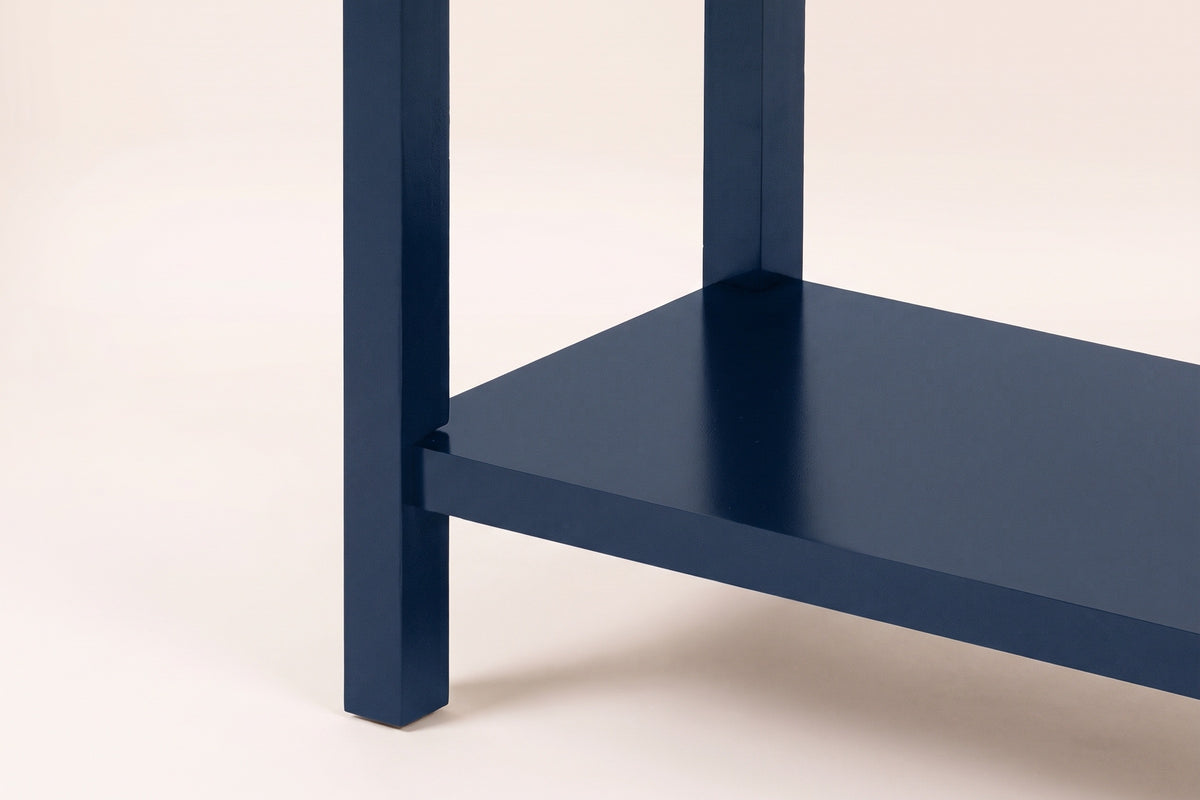 Close-up of a navy blue square leg and the lower shelf meeting it