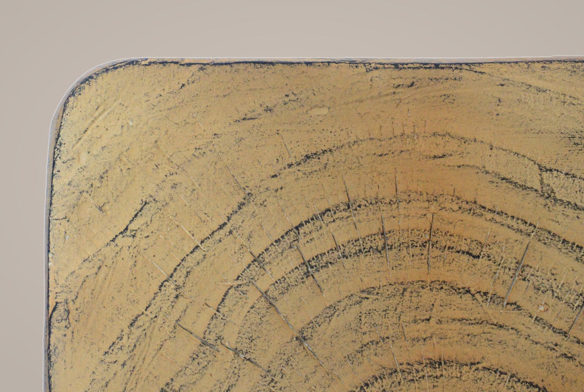 Close-up of the top corner: cast tree rings, fine radial cracks and a grey patina on the rounded edge
