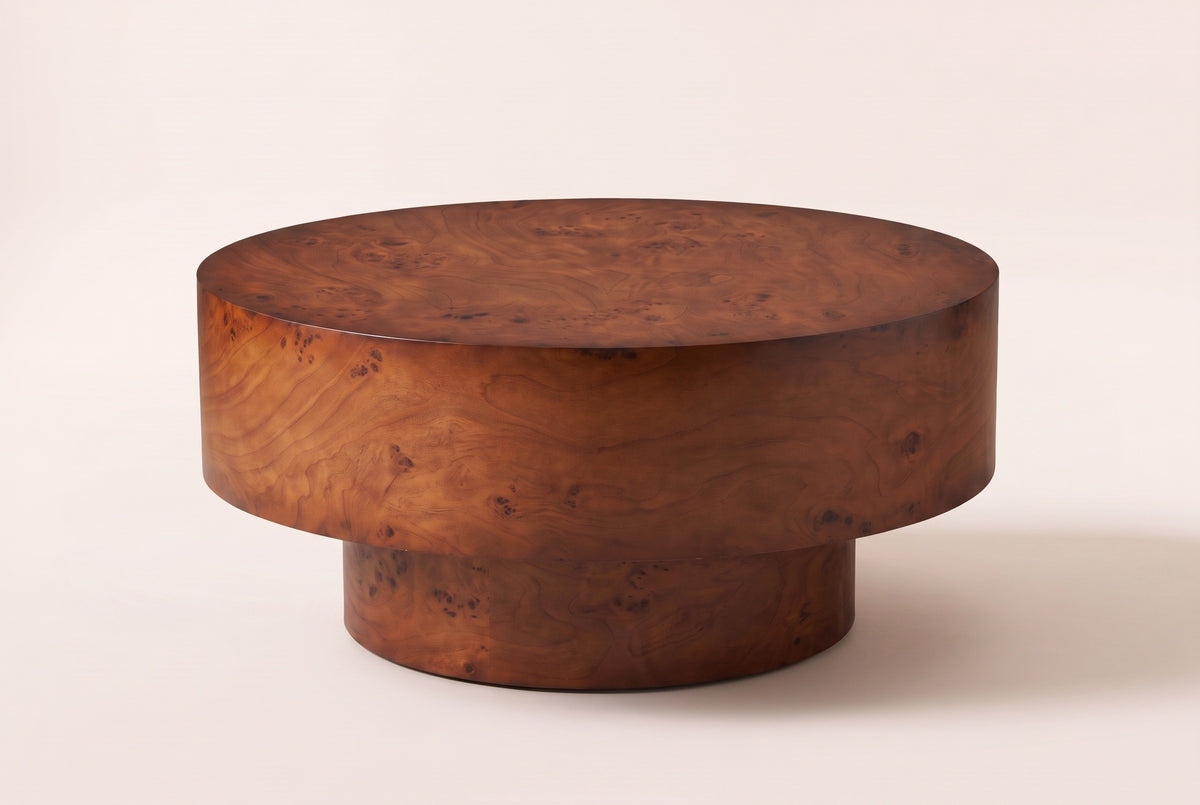 Vieste round drum coffee table in a walnut-tone burl veneer finish, three-quarter view on a warm cream studio backdrop