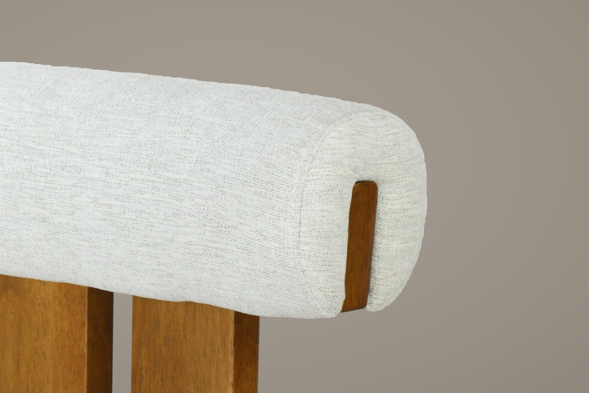 Close-up of the ivory woven upholstery of the Vigoleno bolster backrest, with the walnut tab at its end