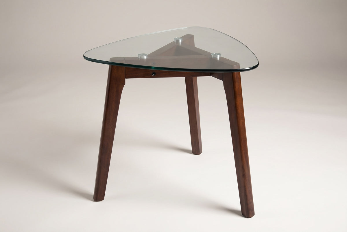 Vipiteno glass-top side table in walnut, three-quarter view on a warm grey studio backdrop