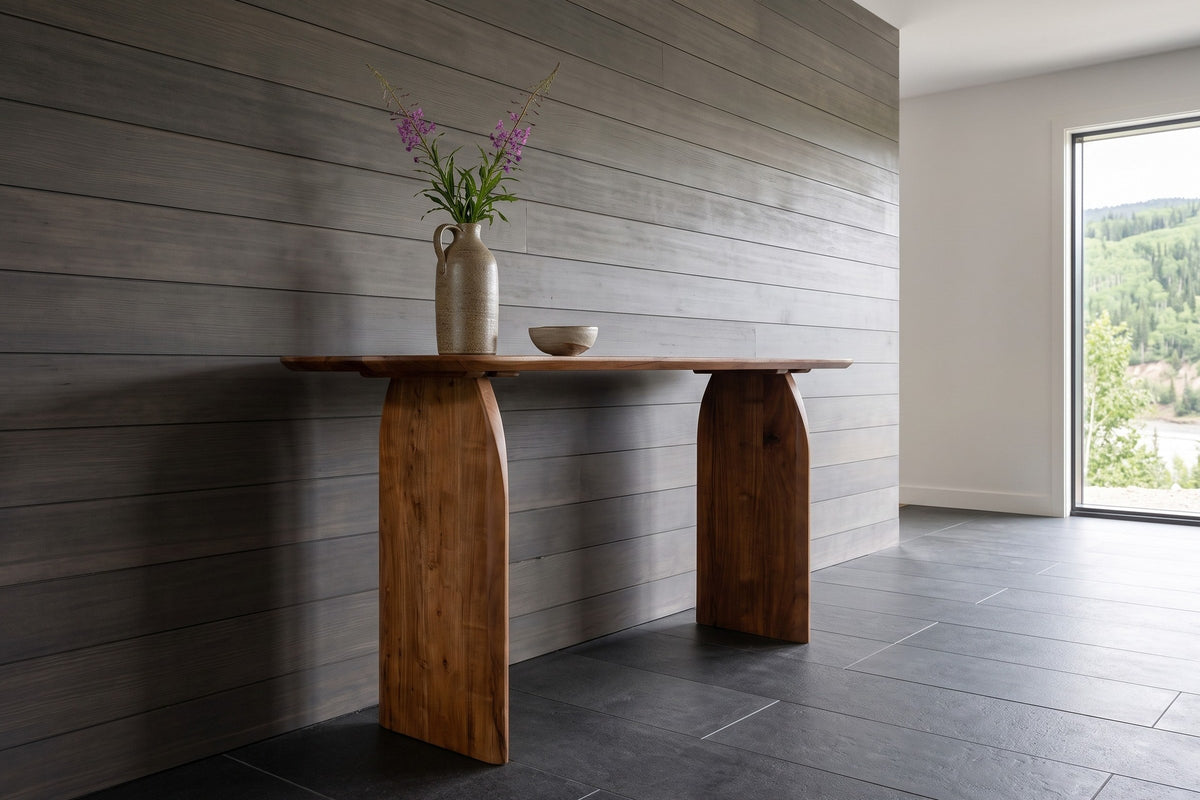 End view of the Visso console table in Pecan against smoked grey cedar boards in a Dawson City house