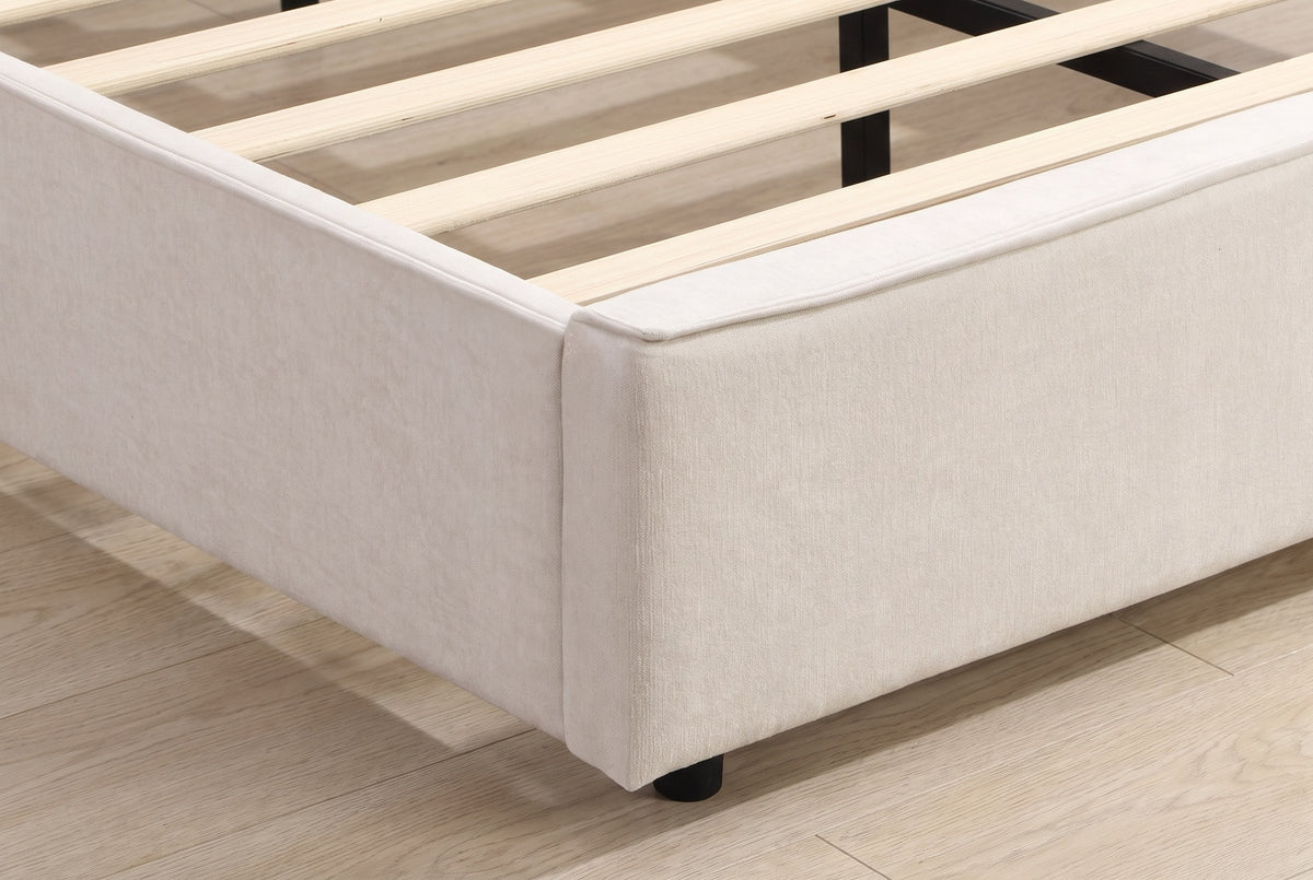 Close-up of the upholstered foot corner of the Viterbo bed with its flange seam, the slats and a short black foot