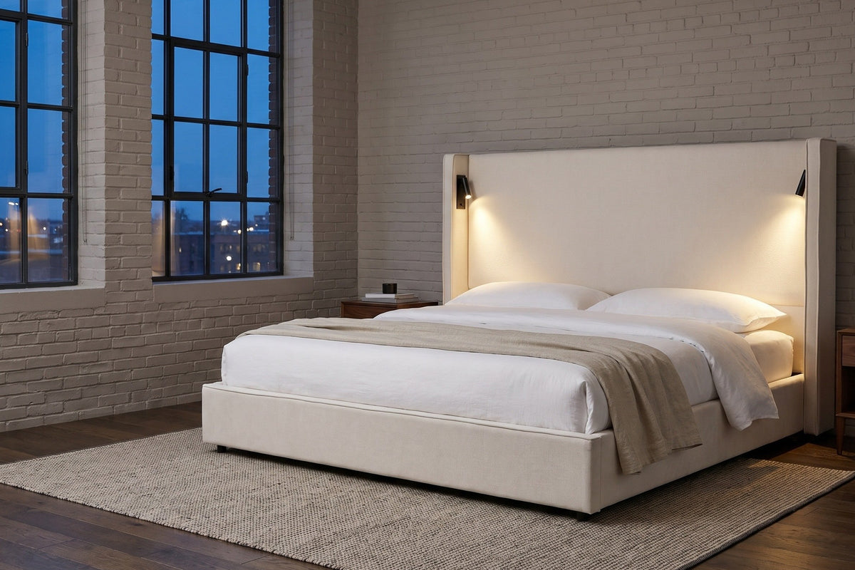 Viterbo bed in a brick-walled loft bedroom at dusk, both built-in reading lamps glowing on the headboard
