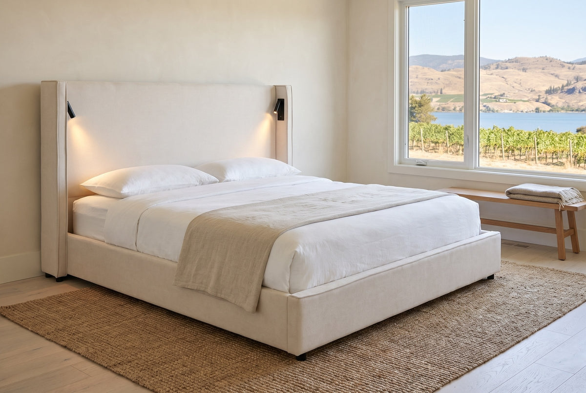 Viterbo bed in a lake house bedroom with a jute rug and a window onto vineyards, dry hills and a blue lake