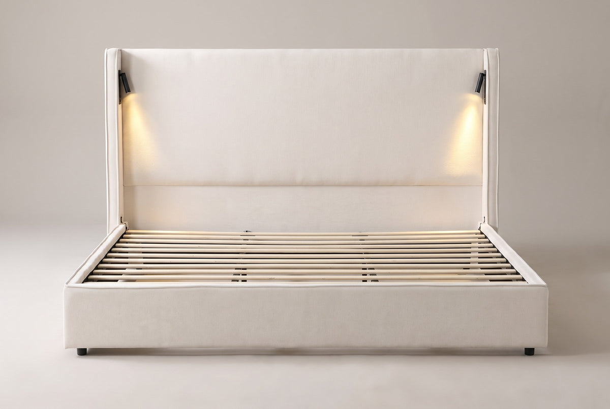 Viterbo shelter bed in beige, straight front view: tall flat headboard between two wings, a lit reading lamp inside each wing