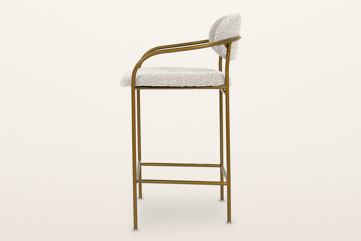 Vitorchiano counter stool in profile: the front leg bending back into the arm, the back pad on the rear legs, the footrest frame low down