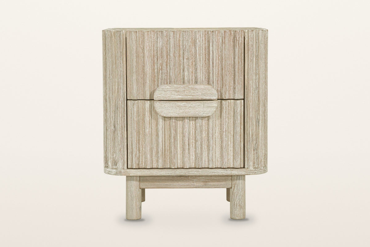 Vitorchiano nightstand in Natural White Wash, front view on a warm white studio backdrop: two reeded drawers and the split ov