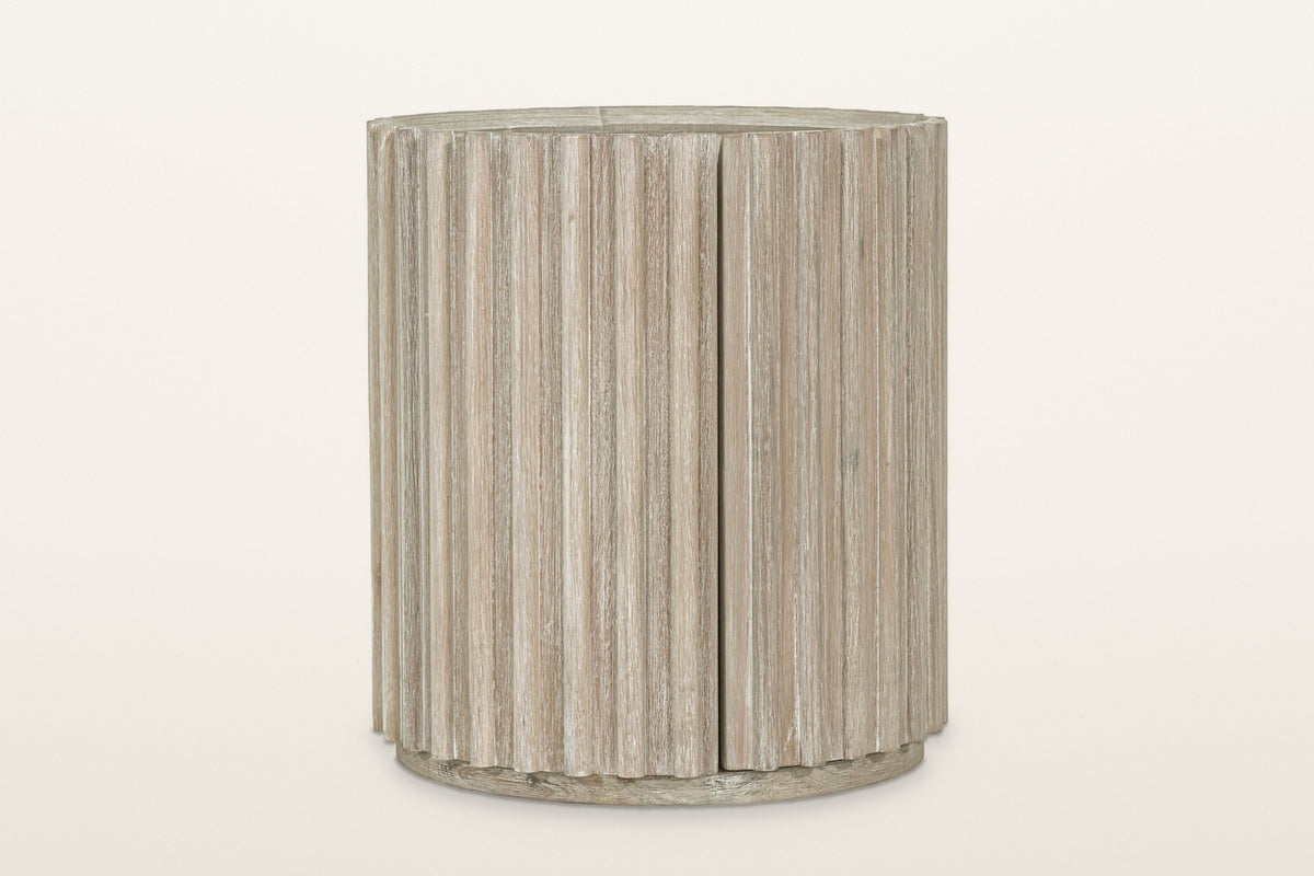 Vitorchiano side table in Natural White Washed from the front, on a warm white studio backdrop: the reeded drum