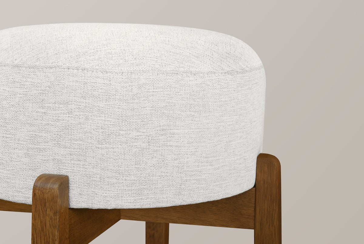 Close-up of the Vogogna ivory linen-look drum cushion held in the notched tops of the Dark Walnut legs