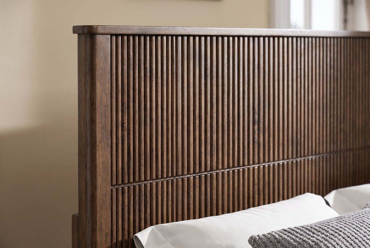 Close-up of the reeded walnut headboard, its flat capped top rail and square post
