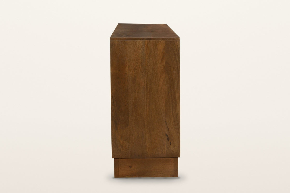 The end of the Zibello sideboard in Light Walnut on a warm white studio backdrop: a plain mango end panel above the recessed