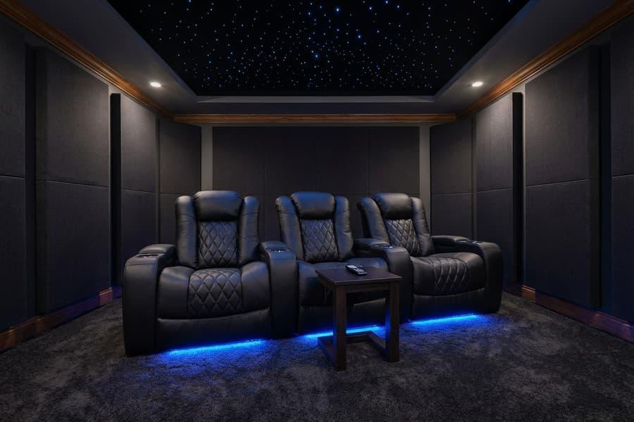 Luxury dedicated home theater room with dark leather recliners and acoustic wall panels