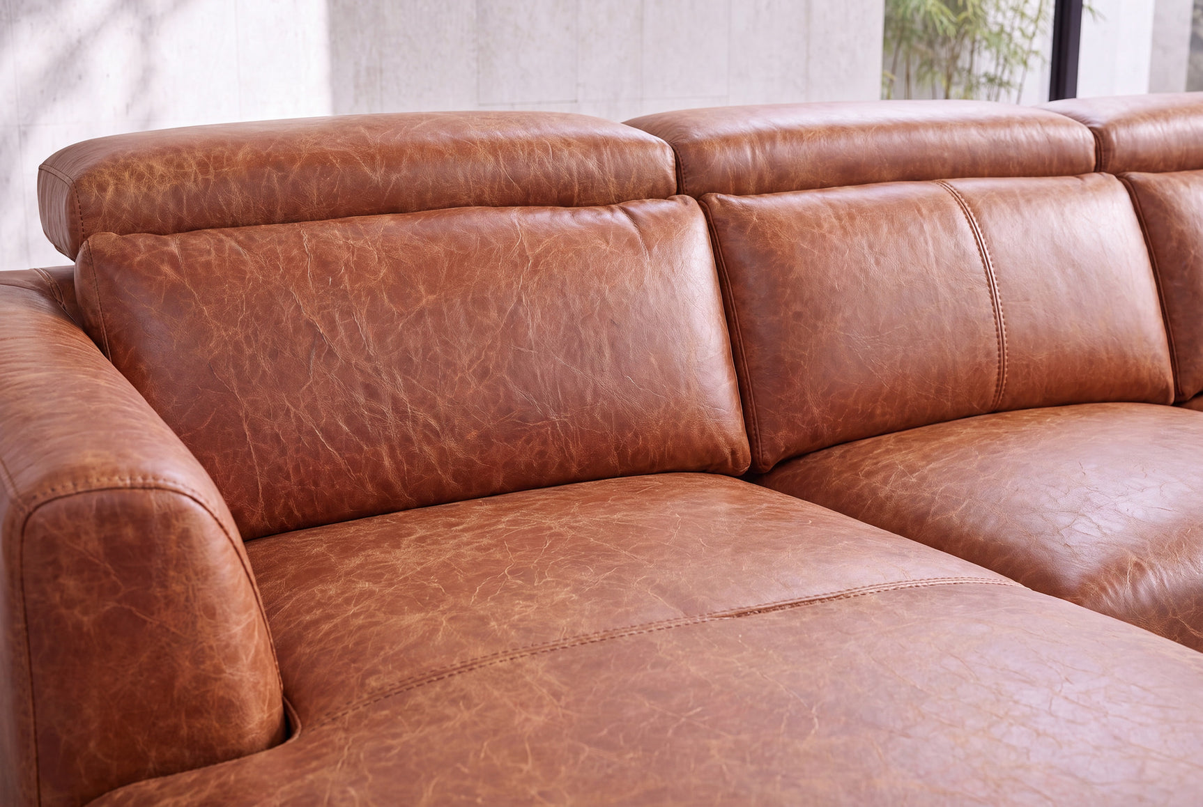 Close-up of Andria distressed Italian aniline leather seats, armrest, and padded headrests