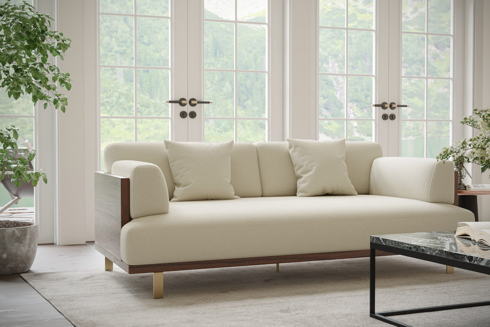 In a Living Room, There is Left Acute Angle Front View of A Luxurious, Beige, Kiln Dried Wood Frame, Emilia Modern Fabric Sofa with Two Cushions on It.