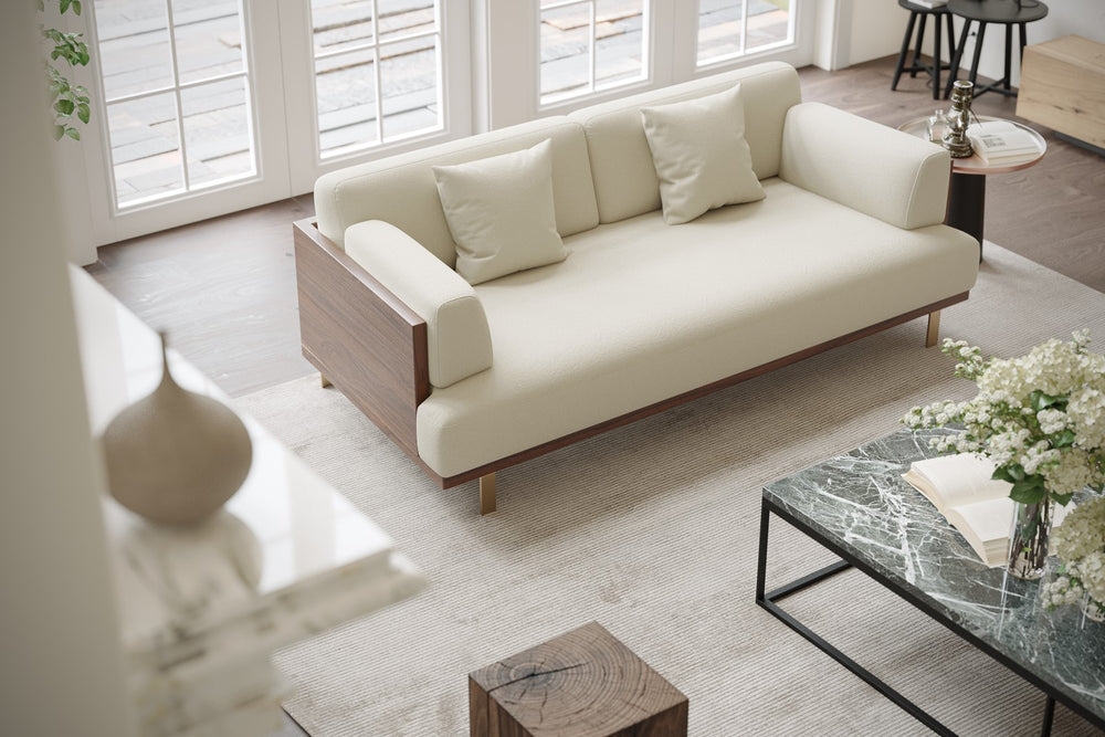 In a Living Room, There is Left Acute Angle Front Top View of A Luxurious, Beige, Kiln Dried Wood Frame, Emilia Modern Fabric Sofa with Two Cushions on It.