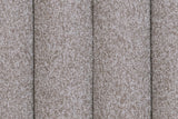 Close-up of the Abbadia channels in stone: deep grooves between rounded rolls of flecked warm grey fabric