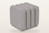Abbadia channel-tufted square ottoman in stone, three-quarter view on a warm white studio backdrop