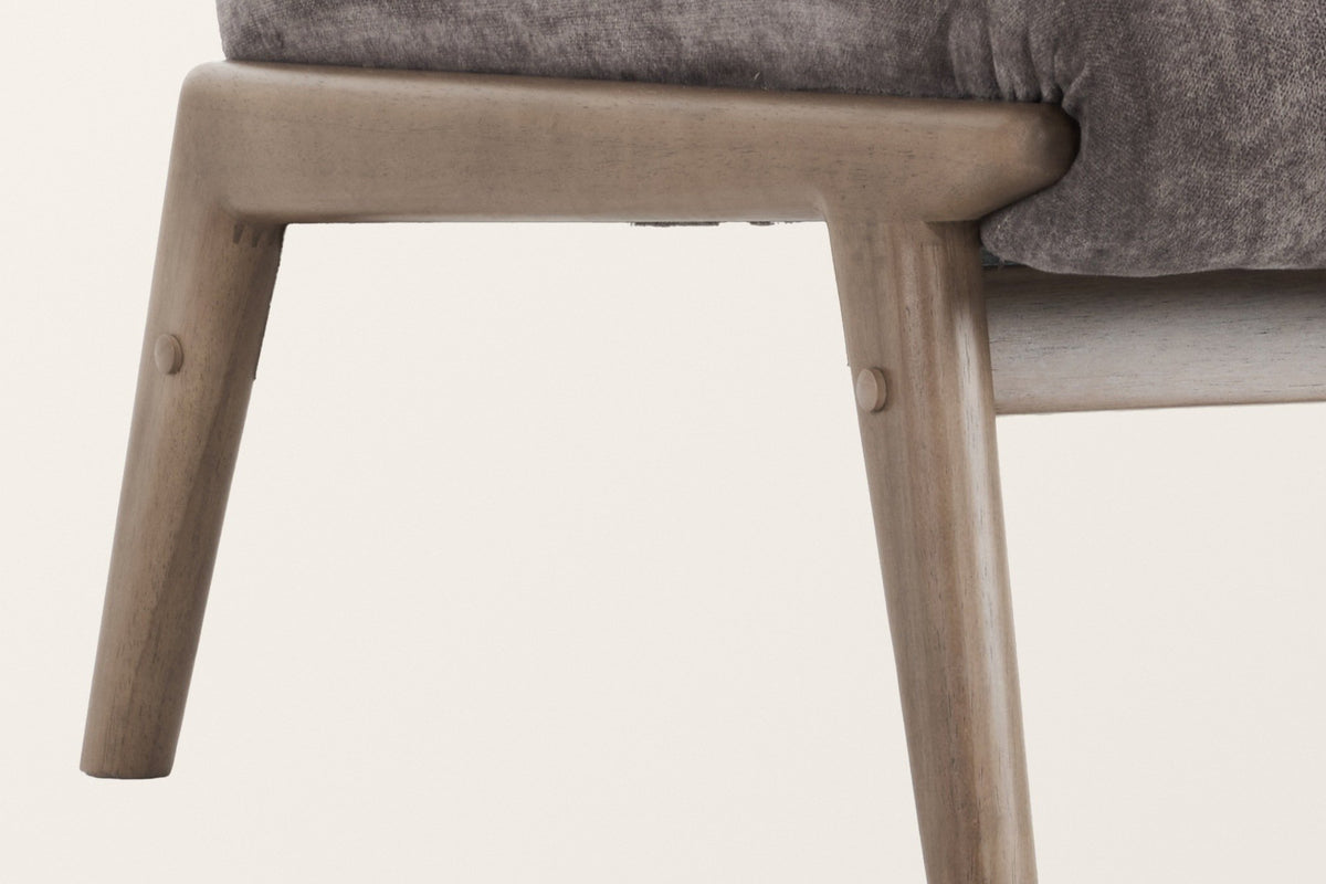 Close-up of the Acquasparta wood frame: the rounded end of the side rail under the seat